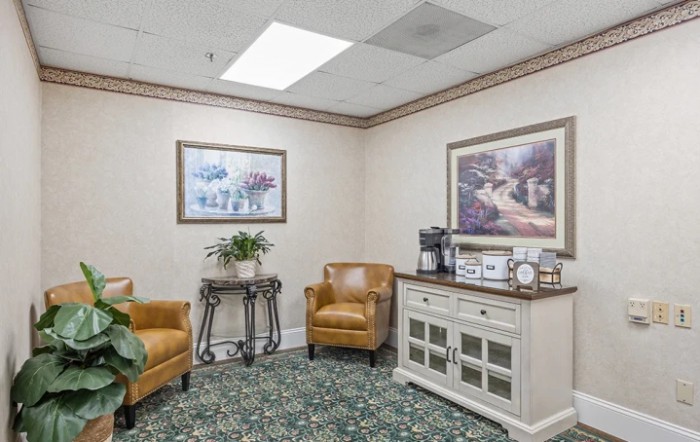 A cozy waiting room with comfortable seating, art on the walls, and a coffee station.