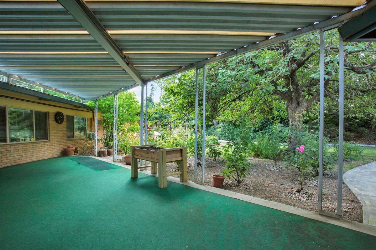 A tranquil patio area overlooking a lush garden with abundant greenery.