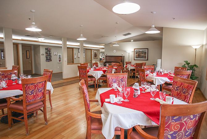 A well-arranged dining area with red tablecloths and neatly set tables, ready for guests.