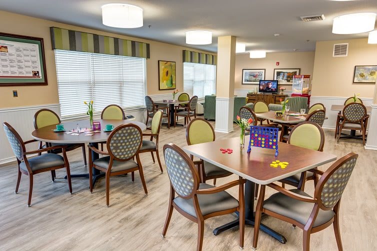 A cozy dining and community area with several tables and chairs arranged for group seating.