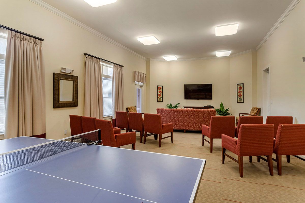 A lounge area featuring a ping pong table, comfortable seating, and a television.