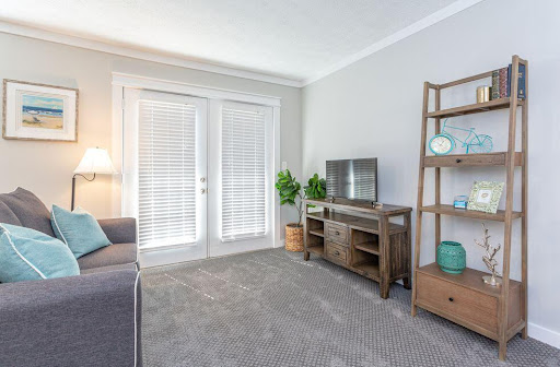 A cozy and modern living room featuring a comfortable seating area, elegant shelving, and ample natural light.