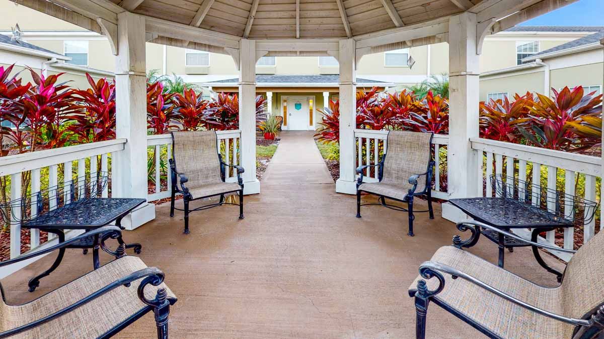 A welcoming gazebo with benches, surrounded by vibrant landscaping.