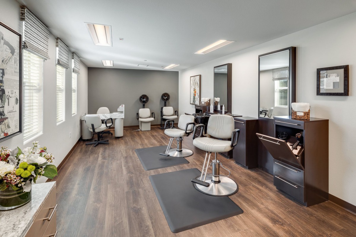 A modern hair salon interior with stylish chairs and mirrors.