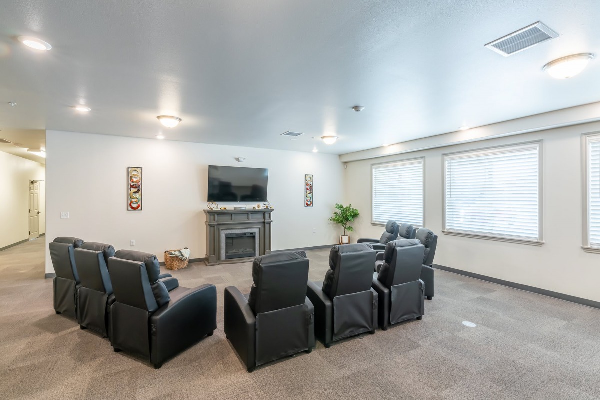 A modern home theater setup with comfortable armchairs and a large TV.