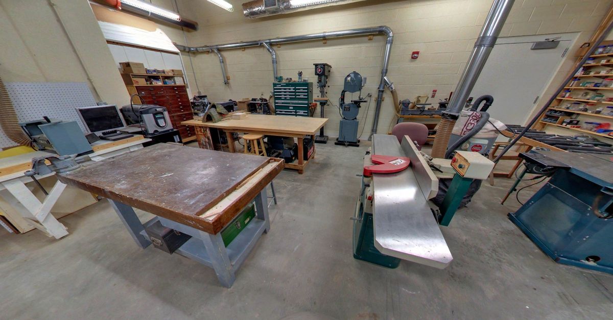 A well-equipped woodworking workshop featuring various tools and workbenches.