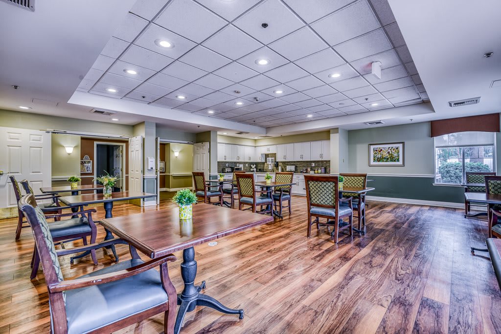 A spacious dining area with wooden floors and modern lighting.