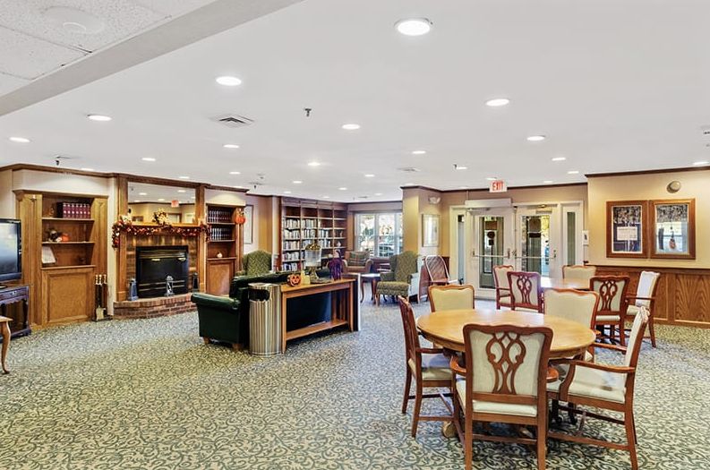 A cozy library lounge featuring bookshelves, comfortable seating, and a fireplace.