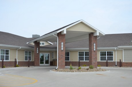 A modern residential building featuring a welcoming entrance with columns and large windows.