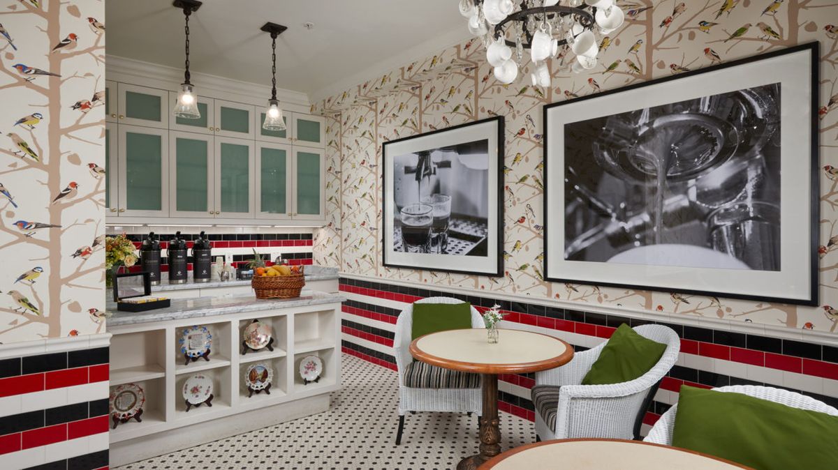 A vintage-style kitchen with black and white photos, cozy seating, and patterned flooring.