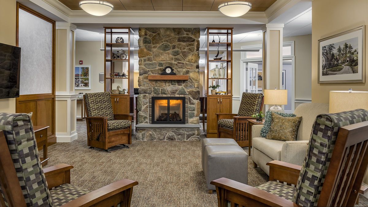 A cozy living room featuring a stone fireplace, comfortable seating, and warm lighting.