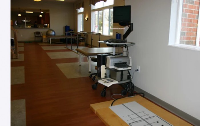 A rehabilitation room equipped with medical and exercise equipment for physical therapy.