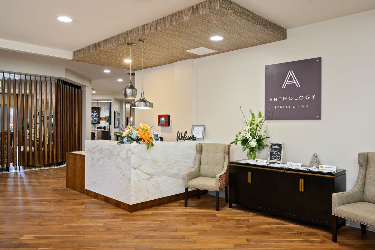 A modern office reception area with elegant marble counters and floral decorations.