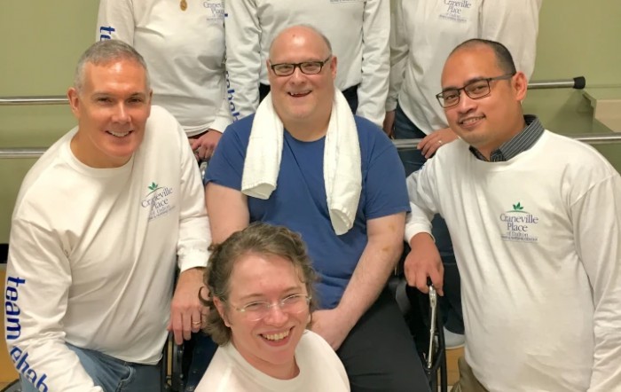 A group of people posing together for a photo indoors, all smiling.