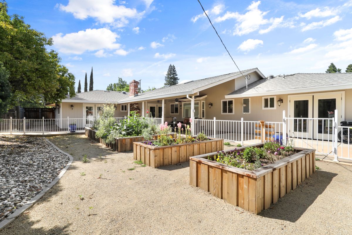 A spacious backyard with planter boxes under a clear blue sky.