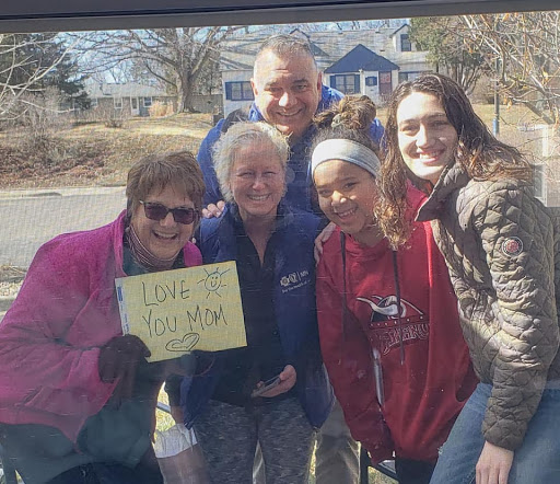 A joyful gathering of friends and family, holding a sign and sharing smiles.