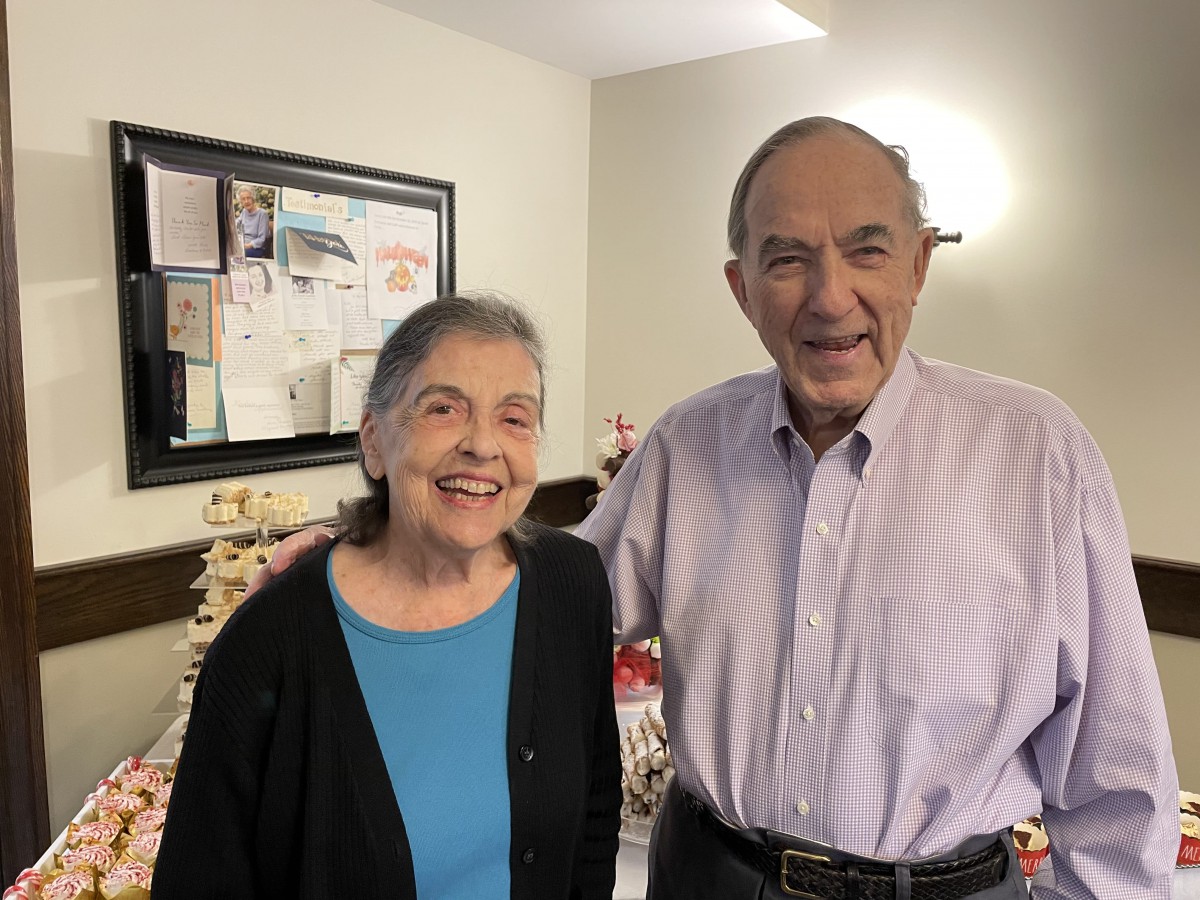 An elderly couple smiling together indoors.