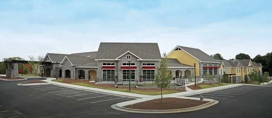 A commercial building with a parking lot and storefront, featuring a simple architectural design.