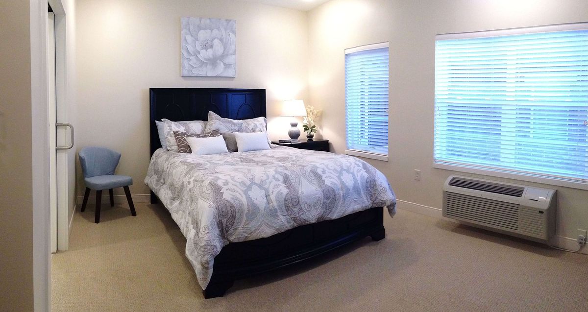 A cozy and elegantly decorated bedroom with a large bed, soft bedding, and natural light from the windows.