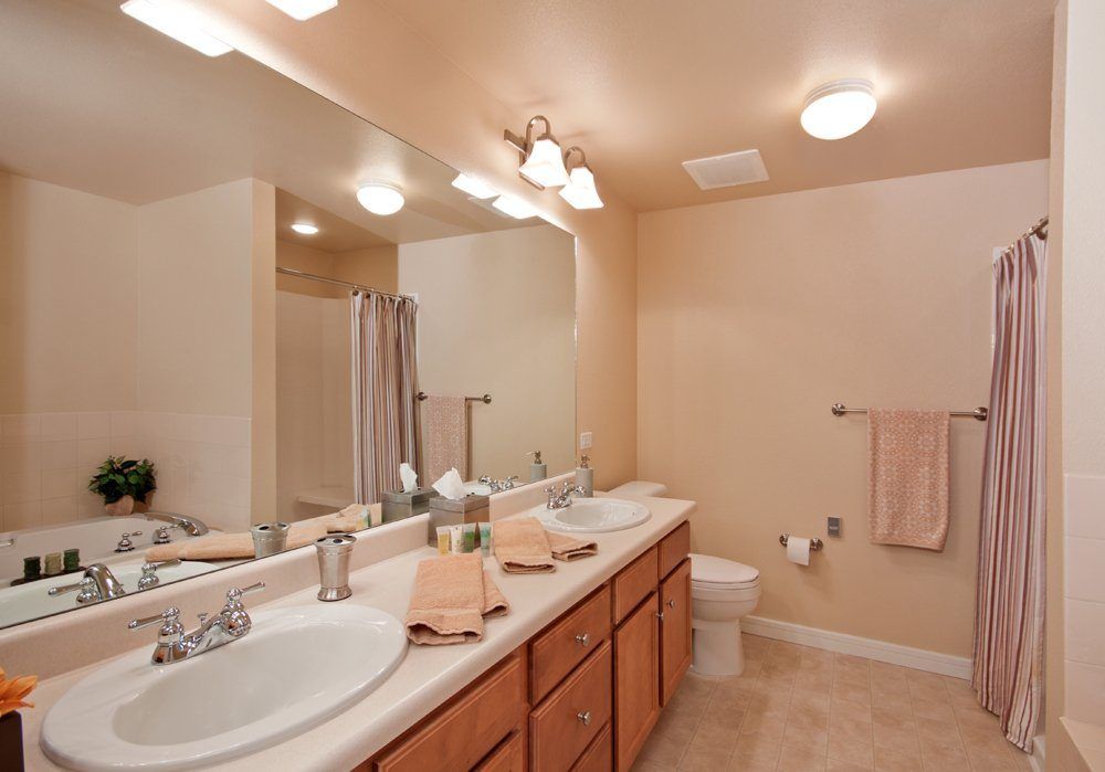 A spacious bathroom featuring a double sink vanity and modern fixtures.