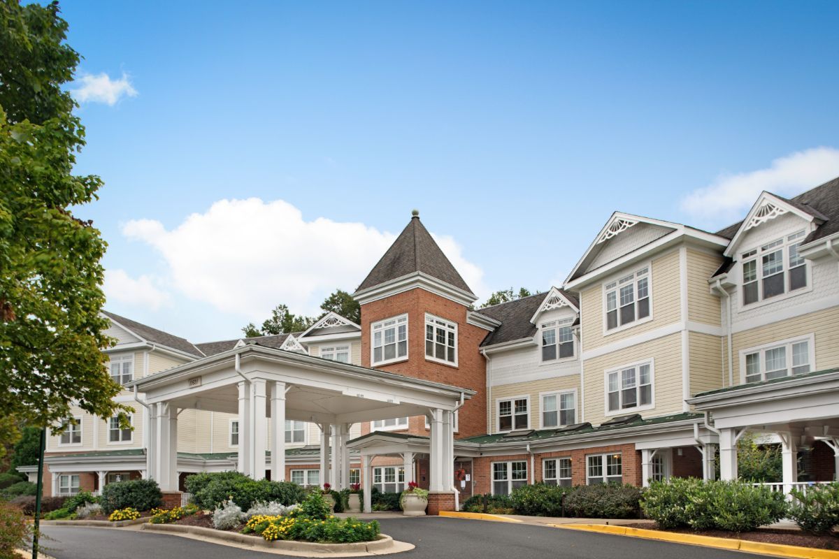 A large residential building with a prominent entrance under a clear sky.
