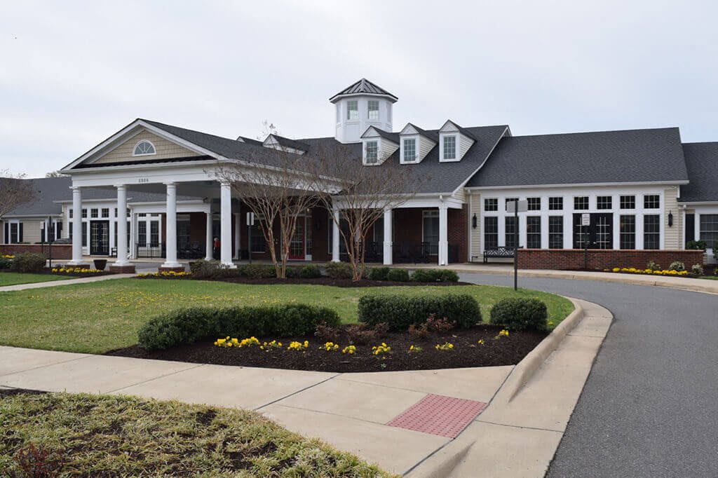 A well-maintained building with a landscaped garden and driveway.