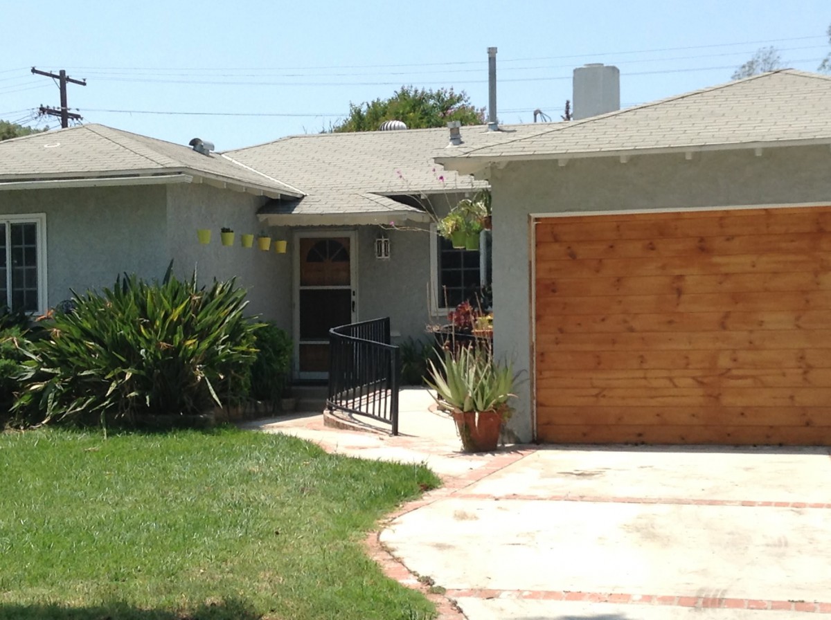 A single-story house with a driveway, garage, and front yard.