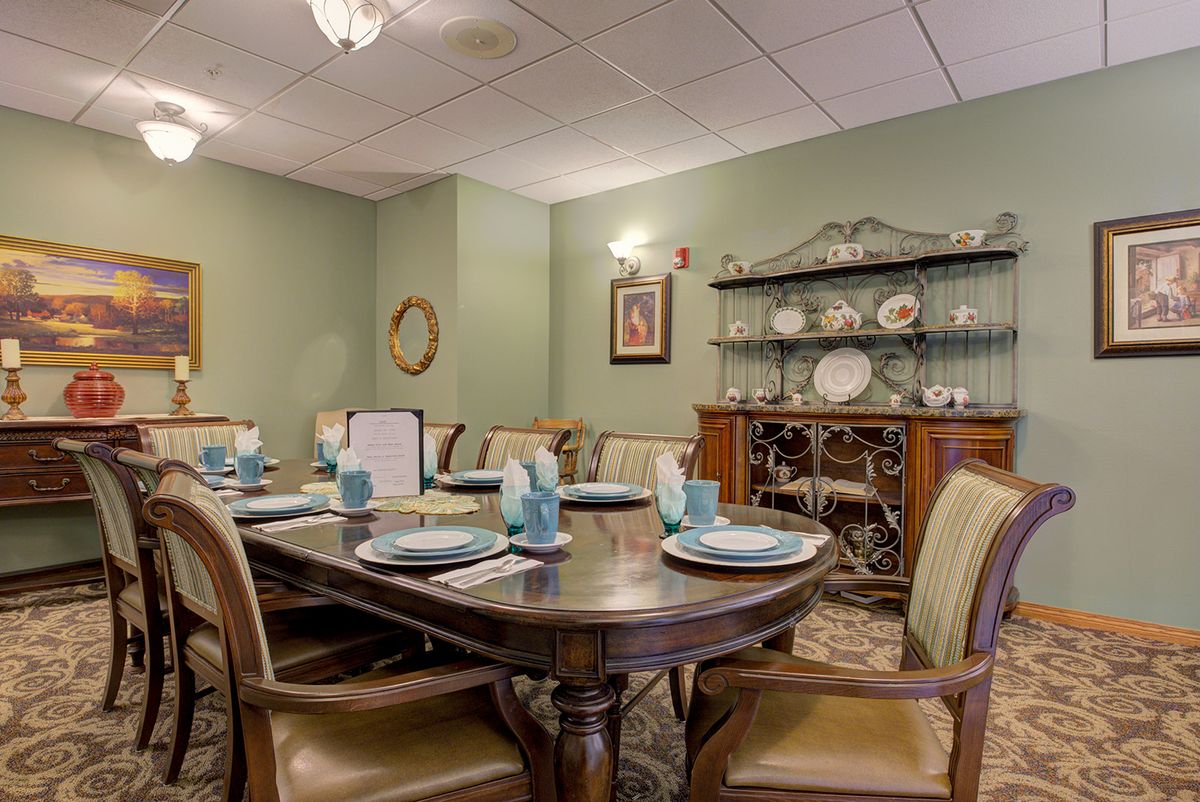 An elegantly set dining room with classical furniture and decorative plates.