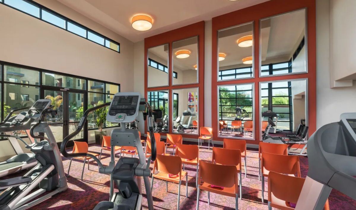 Modern gym with exercise equipment and seating area.