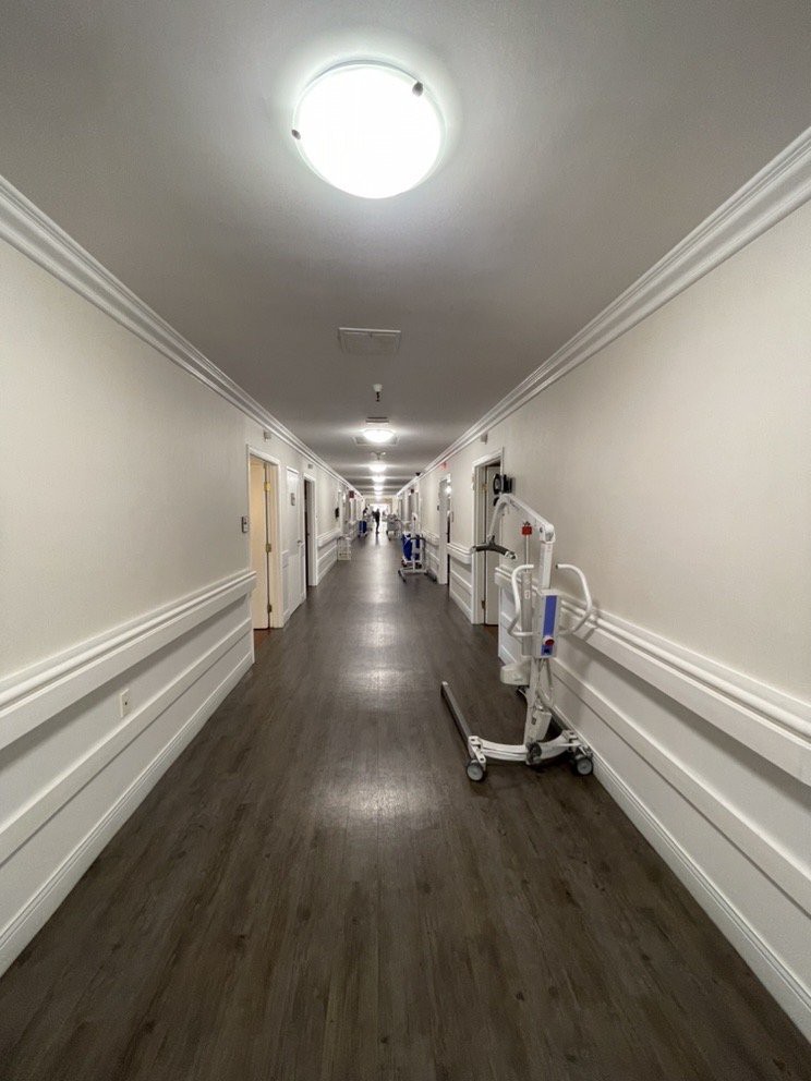 A long hospital hallway with medical equipment along the walls.