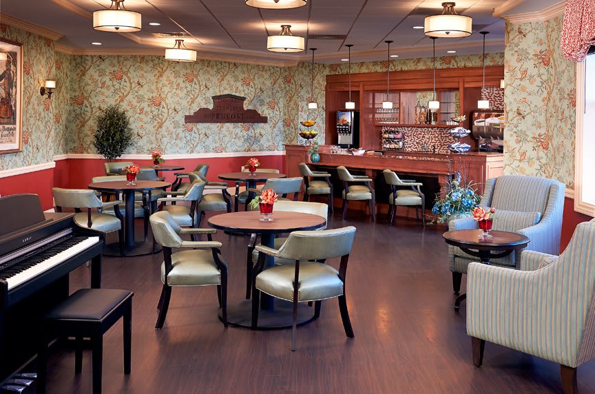Cozy restaurant interior with elegant tables, chairs, and a stylish bar area.