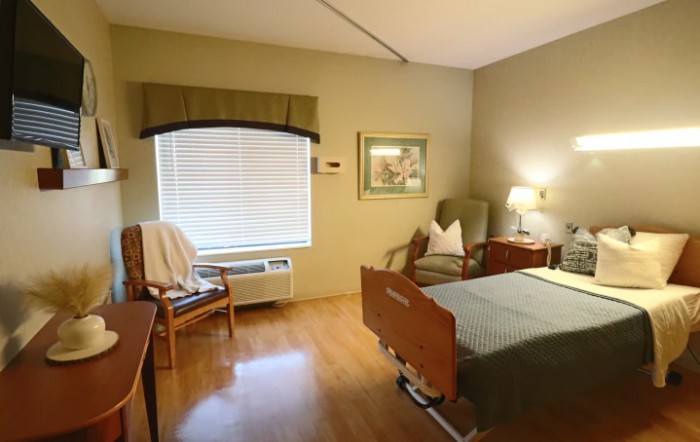 A cozy room with a hospital bed, wooden furniture, and soft lighting.