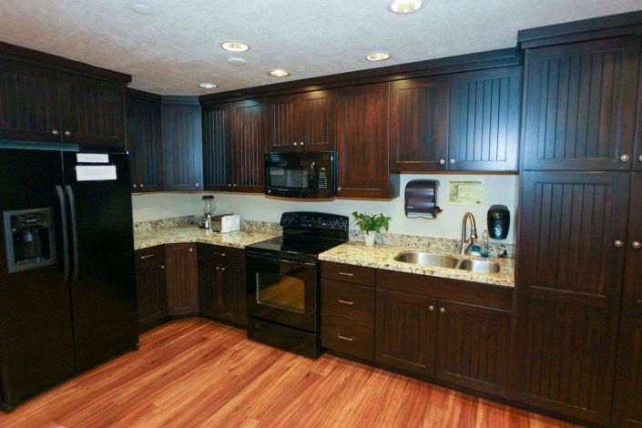 Modern kitchen with dark wood cabinets and appliances.