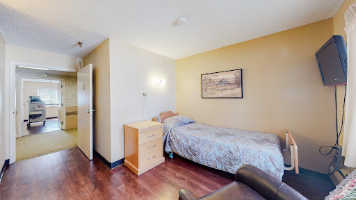 A cozy single bedroom featuring a simple design with wooden flooring and minimalist decor.