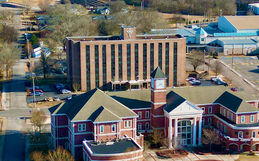 Aerial view of a distinctive architectural complex featuring a hotel and adjacent building with a clock tower.