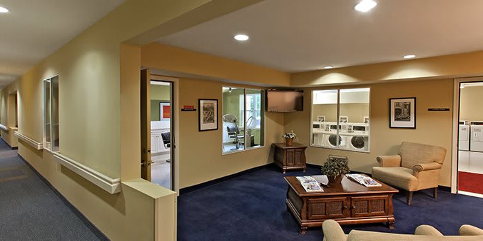 A cozy office waiting area with comfortable seating, a coffee table, and large windows.