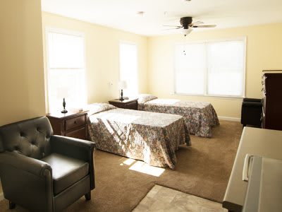 A brightly lit bedroom with twin beds and cozy furnishings.