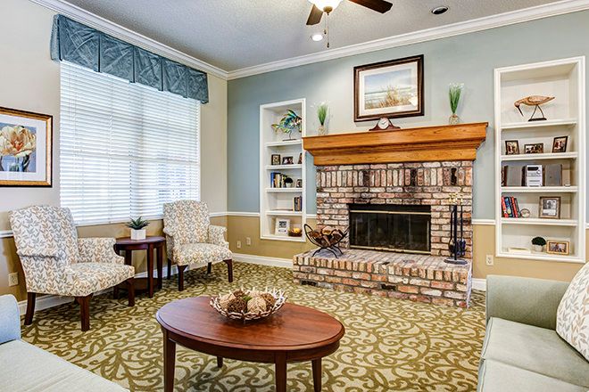 A cozy living room with a brick fireplace and classic decor.