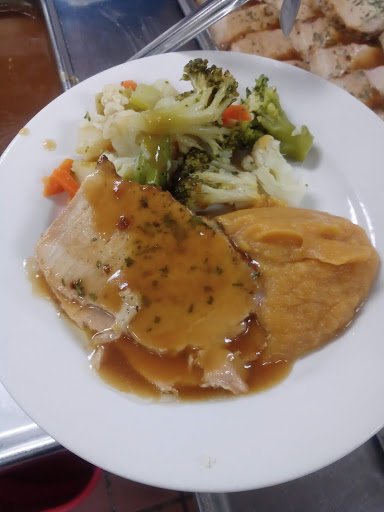 A hearty dinner plate featuring sliced meat with gravy, accompanied by mashed potatoes and a mix of steamed vegetables.