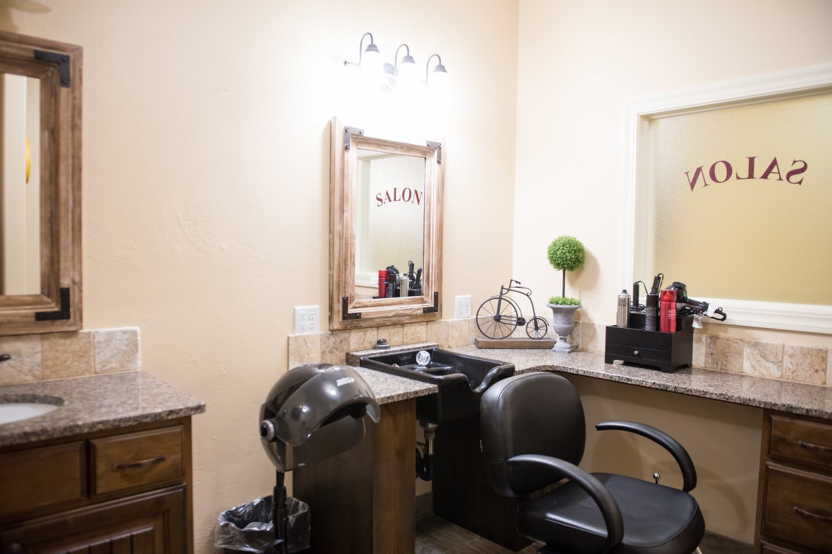 An interior view of a hair salon featuring a styling station with a chair and mirror.