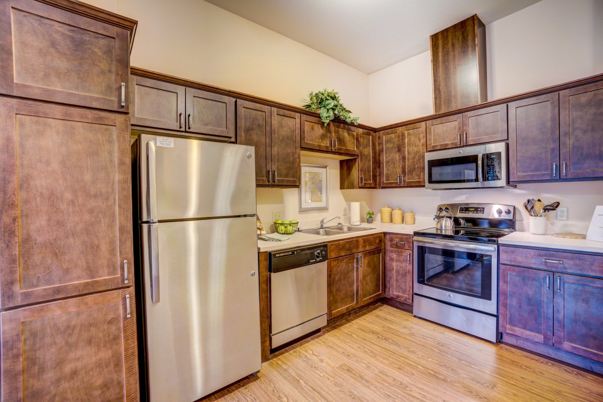 A modern kitchen with stainless steel appliances and wooden cabinets.