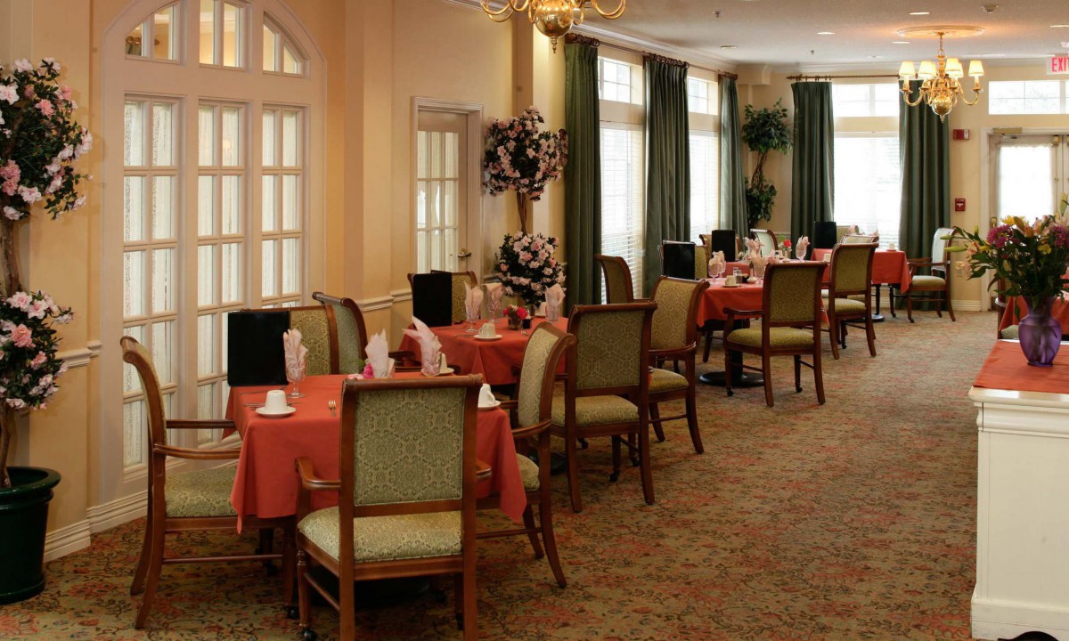 An elegant dining room with neatly arranged tables and chairs, featuring a warm and inviting ambiance.