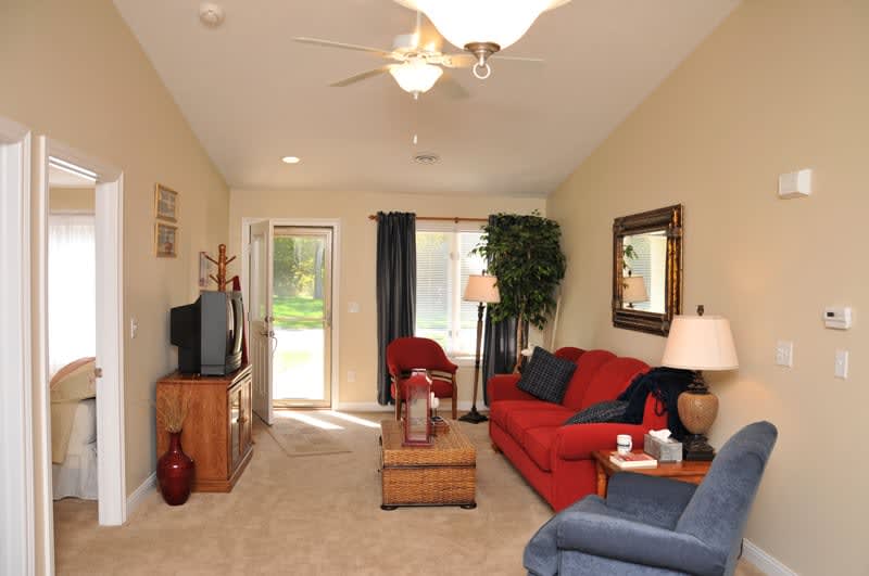 A cozy living room featuring a red sofa, television, and decor elements.