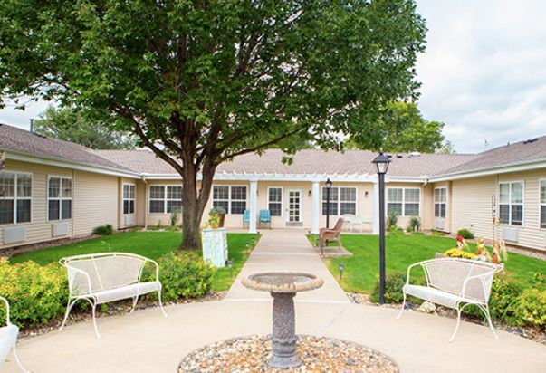A serene courtyard with a central fountain, surrounded by benches and greenery.