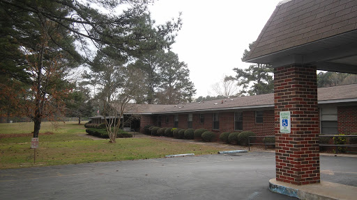A view of a brick building surrounded by greenery, showcasing a calm and quiet environment.