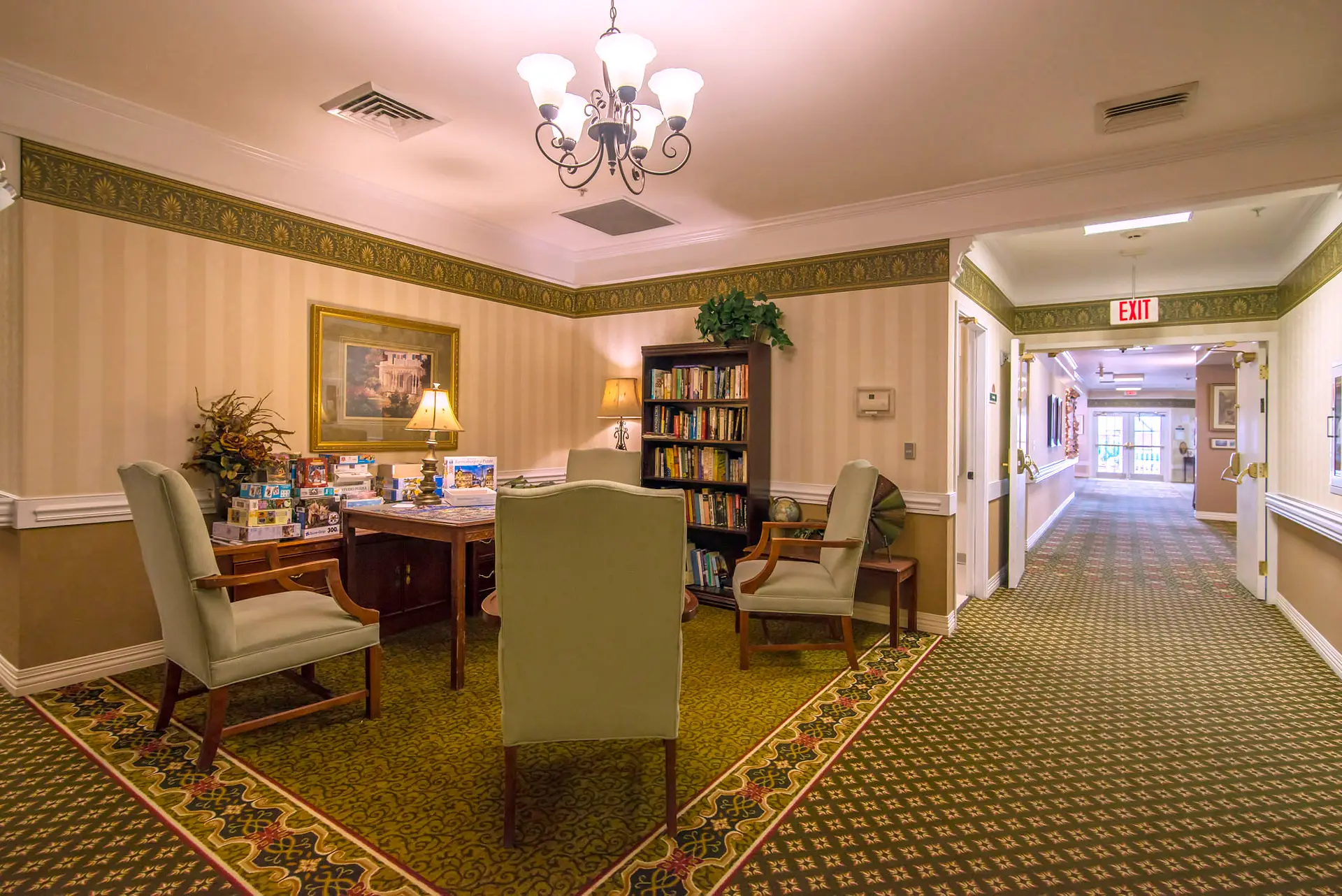 A cozy lounge room with elegant furniture and a well-stocked bookshelf.