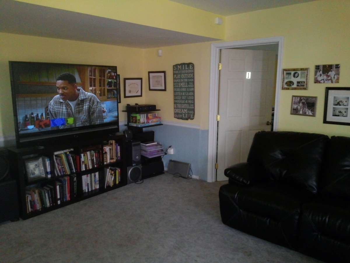 A cozy living room featuring a television, bookshelf, and comfortable seating.