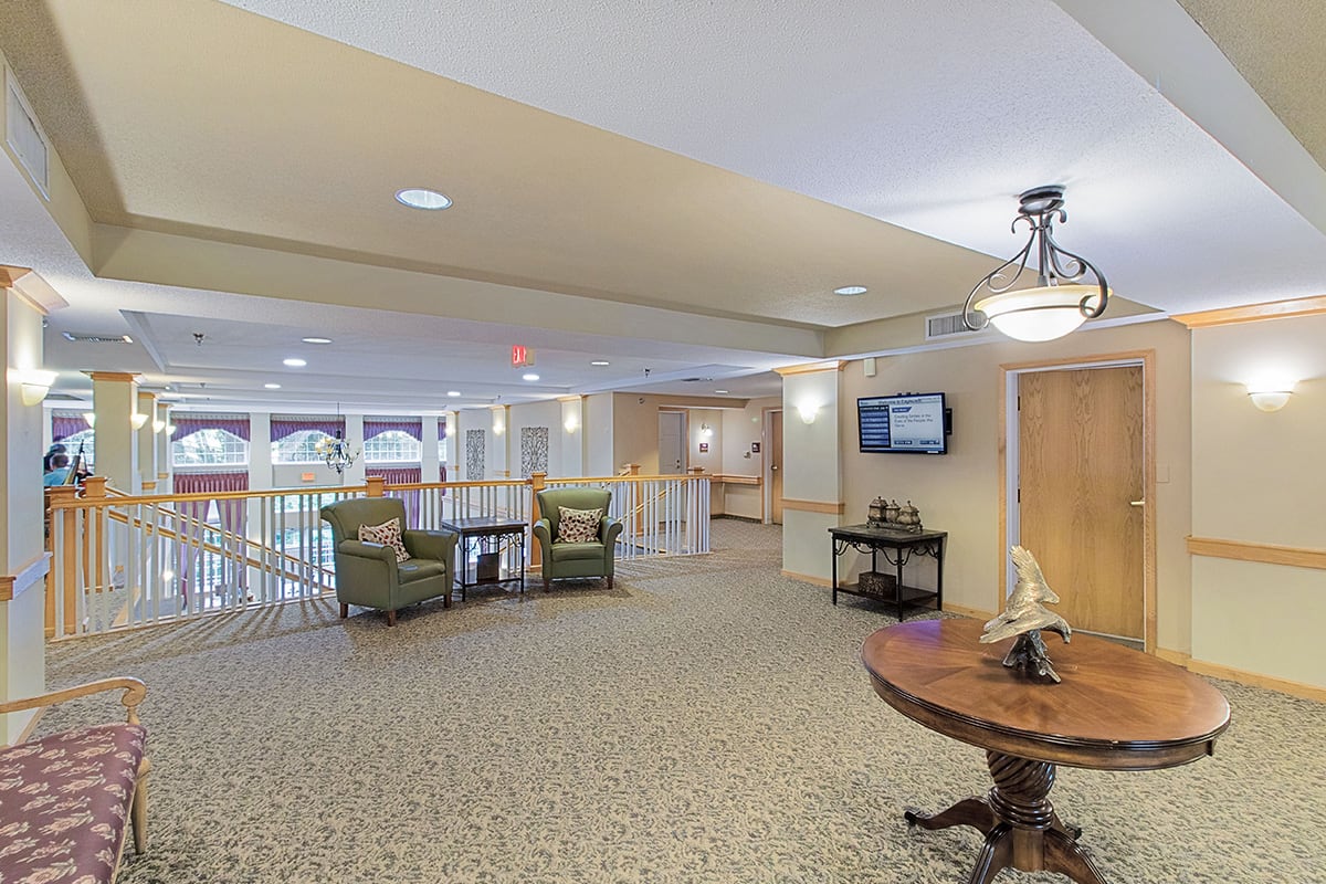 A spacious lobby with comfortable seating, elegant lighting, and a large carpeted area.