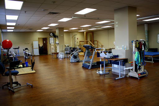 A spacious and well-lit physical therapy room equipped with various rehabilitation tools.
