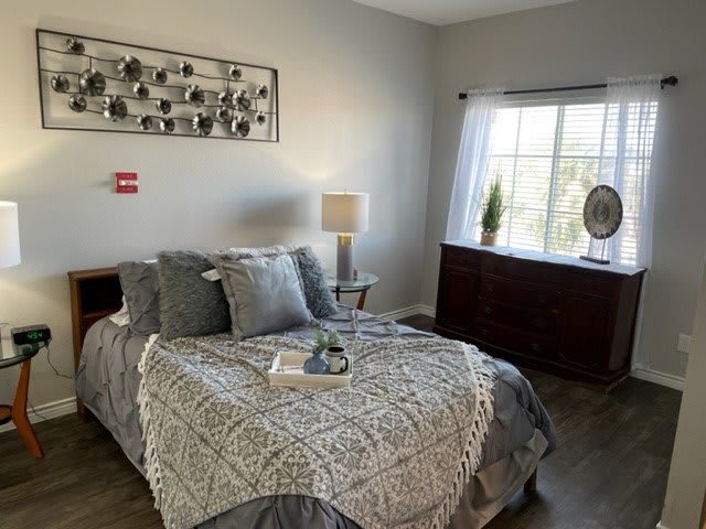 A modern and cozy bedroom with a neatly made bed, stylish decor, and ample natural light.